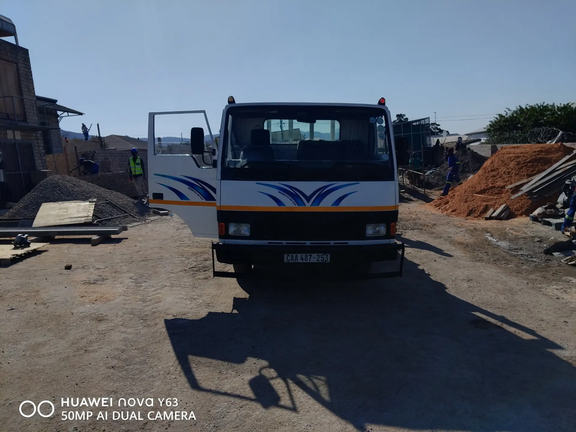 Henry Movers truck delivering building materials to a site